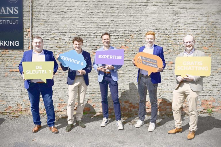 Five men holding colorful speech bubble signs outdoors