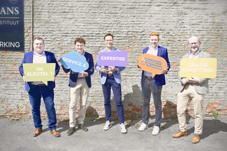 Five men holding colorful speech bubble signs outdoors