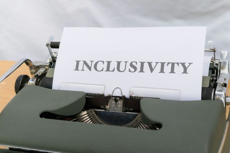 a close up of a typewriter with the word inclusivity on it