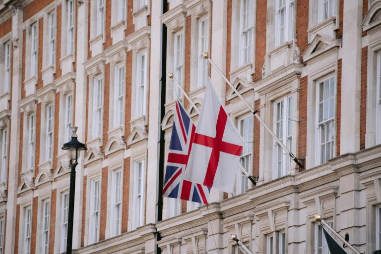 a flag flying in front of a tall building