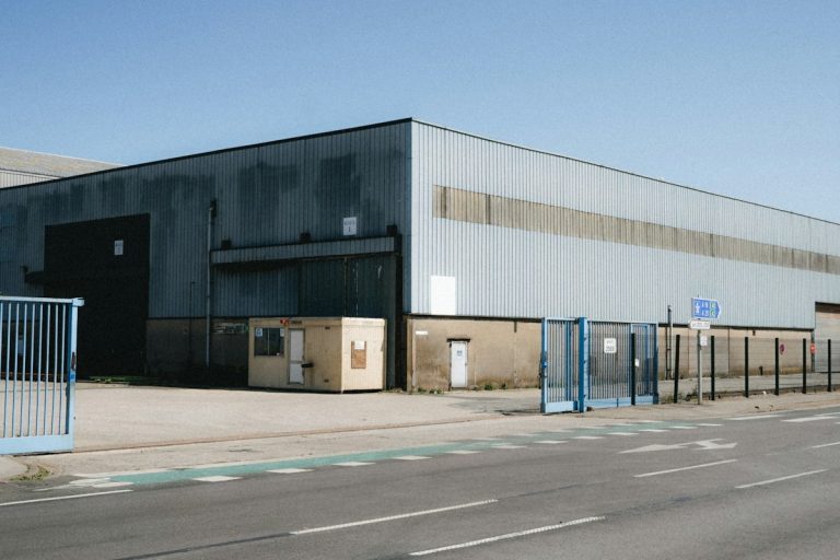 Large industrial warehouse with blue gates and road