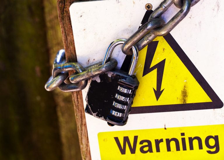 Padlock and chain on a warning sign