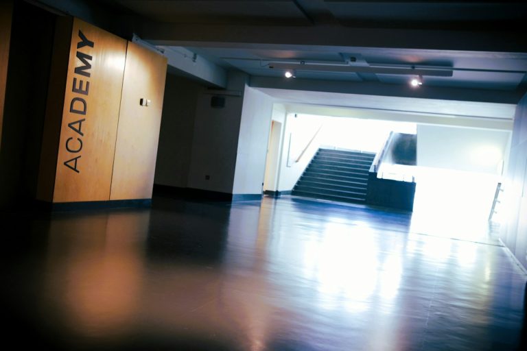 A wooden wall with the word "ACADEMY" in a dimly lit hallway